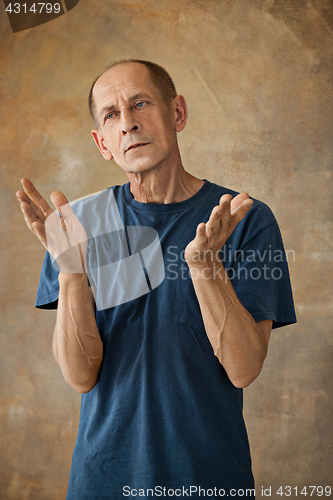 Image of Worried mature man standing at studio