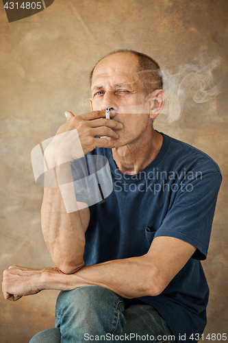 Image of Worried mature man sitting at studio