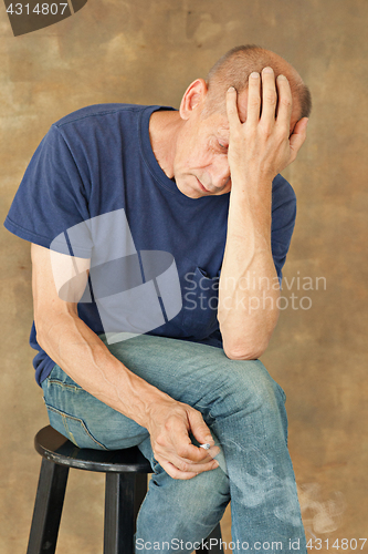 Image of Worried mature man sitting at studio