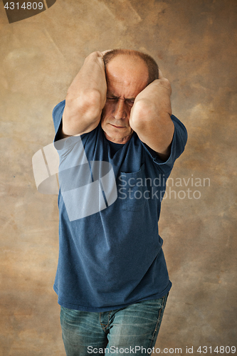 Image of Worried mature man touching his head.