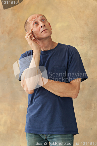 Image of Worried mature man touching his head.