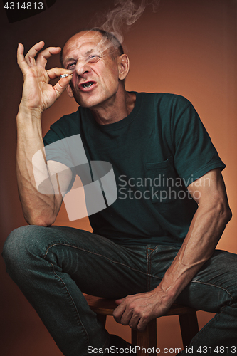 Image of Worried mature man sitting at studio