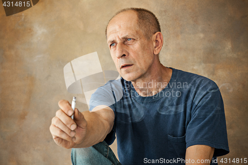 Image of Worried mature man sitting at studio