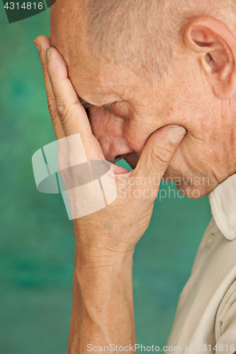 Image of Worried mature man touching his head.