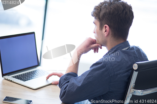 Image of businessman working using a laptop in startup office