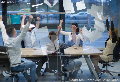 Image of startup Group of young business people throwing documents