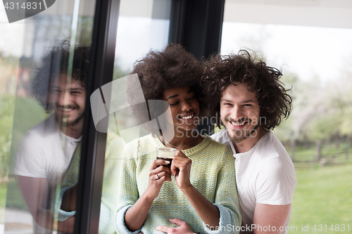 Image of happy multiethnic couple relaxing at modern home indoors