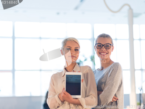 Image of Pretty Businesswomen Using Tablet In Office Building during conf