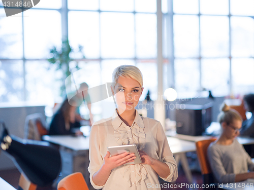 Image of woman working on digital tablet in night office