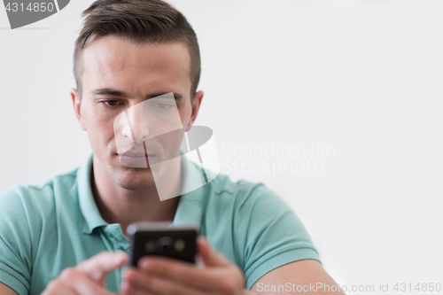 Image of young man using a mobile phone  at home