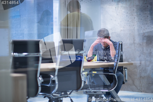 Image of young businessman relaxing at the desk