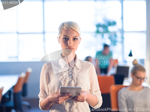 Image of woman working on digital tablet in night office