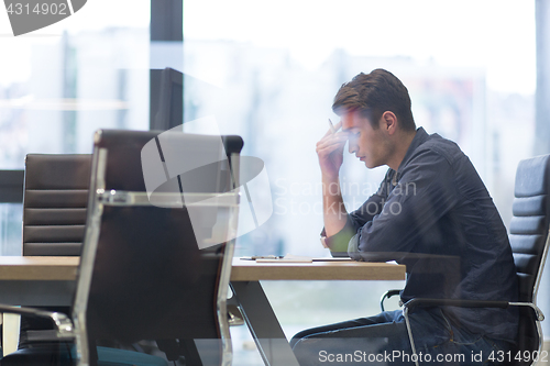 Image of young businessman relaxing at the desk