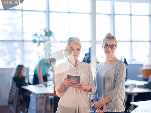 Image of Pretty Businesswomen Using Tablet In Office Building during conf