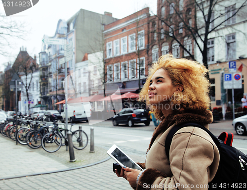 Image of young cute blond african american girl student holding tablet and smiling, lifestyle people concept 