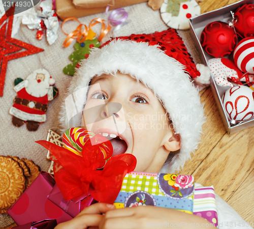 Image of little cute boy with Christmas gifts at home. close up emotional happy smiling in mess with toys, lifestyle holiday people concept