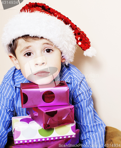 Image of little cute boy with Christmas gifts at home. close up emotional