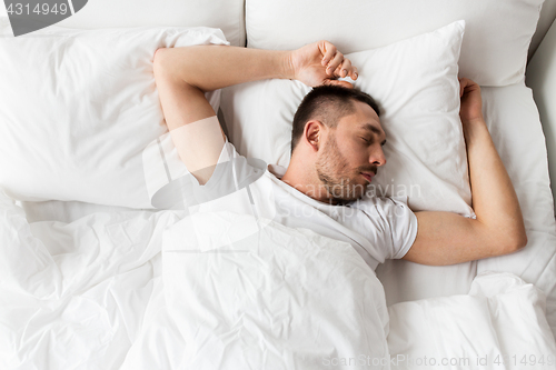 Image of man sleeping in bed at home