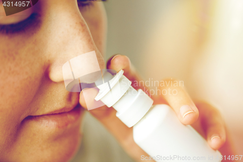 Image of close up of sick woman using nasal spray