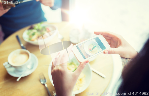 Image of close up of couple picturing food by smartphone