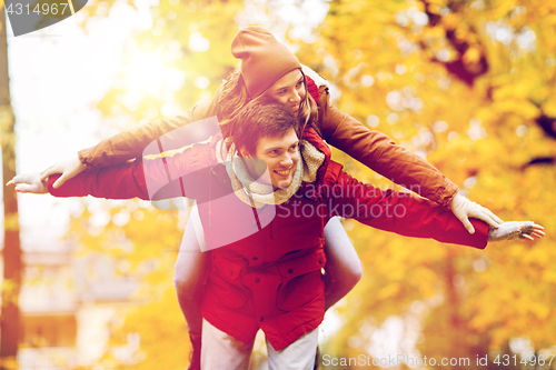 Image of happy young couple having fun in autumn park