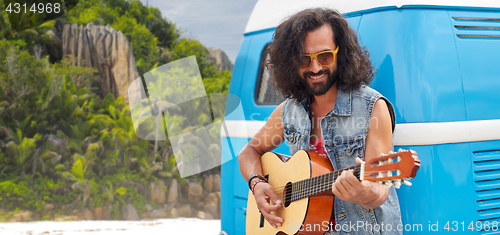 Image of hippie man playing guitar at minivan car on island