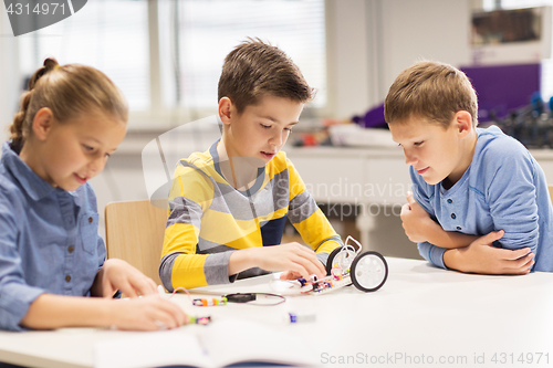 Image of happy children building robots at robotics school