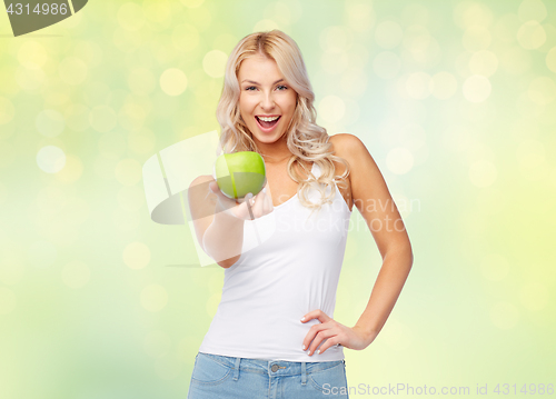 Image of happy beautiful young woman with green apple