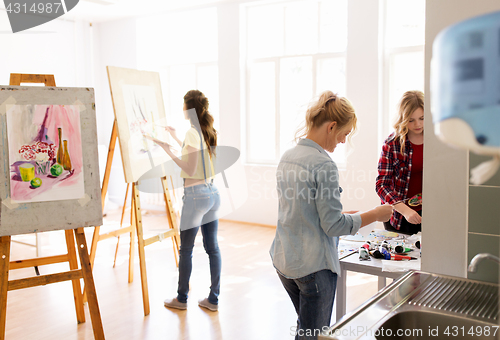 Image of woman artists with colors painting at art school