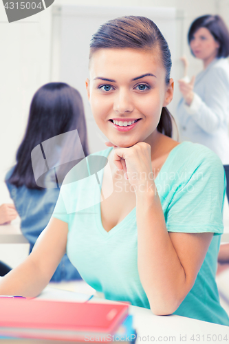 Image of happy smiling student girl with books at school