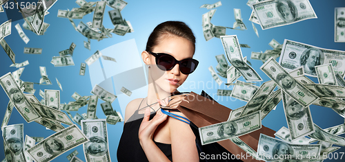 Image of happy woman in black sunglasses with shopping bags