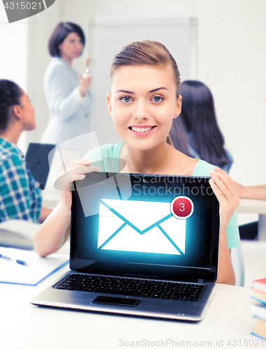 Image of girl holding laptop with email sign at school