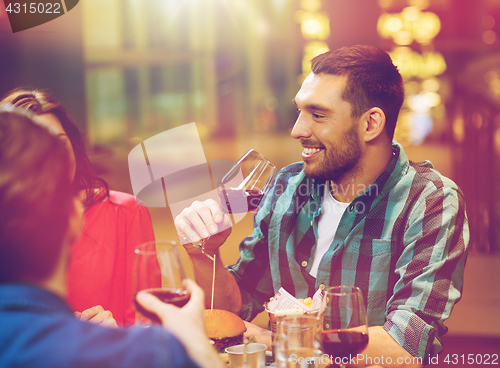 Image of friends dining and drinking wine at restaurant