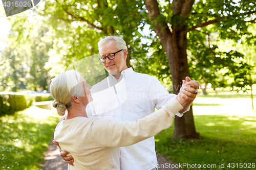 Image of happy senior couple dancing at summer city park