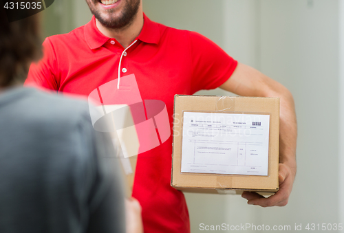 Image of happy delivery man with parcel box and customer