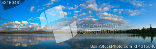 Image of Blue sky with sun over water.