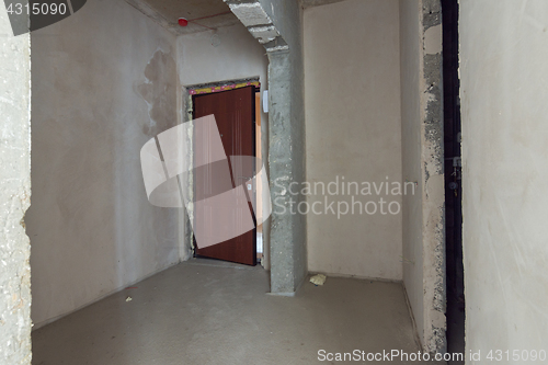 Image of The entrance to the apartment is a new building, the front door and bare concrete and plastered walls