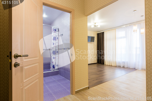 Image of Interior of studio apartment, open door to the bathroom and view of the room