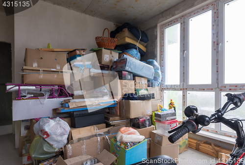 Image of Moving to the apartment a new building, boxes and personal items against the background of concrete walls