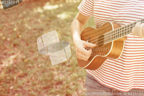 Image of Anonymous woman playing ukulele