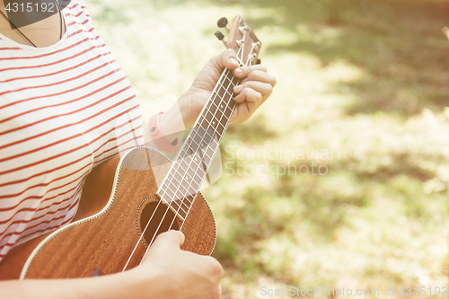 Image of Anonymous woman playing ukulele