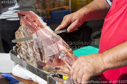 Image of Slicing dry-cured ham prosciutto on the street market