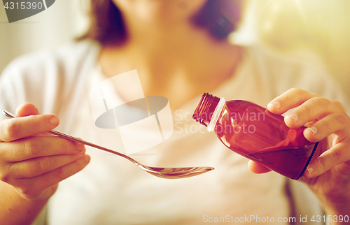 Image of woman pouring medication from bottle to spoon