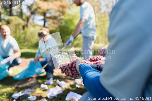 Image of volunteer with trash bag and bottle cleaning area