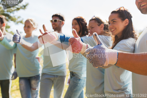 Image of group of volunteers showing thumbs up outdoors