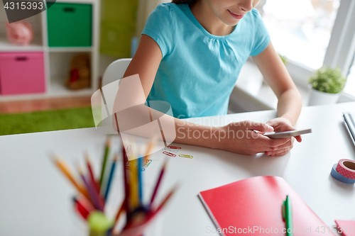 Image of girl with smartphone messaging at home
