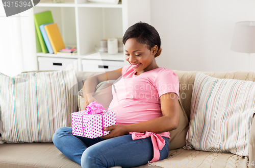 Image of happy african american pregnant woman with gift