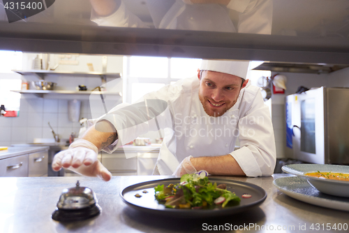 Image of happy male chef cooking food at restaurant kitchen