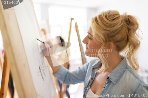 Image of woman artist with pencil drawing at art school