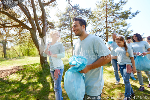 Image of volunteers with garbage bags walking outdoors